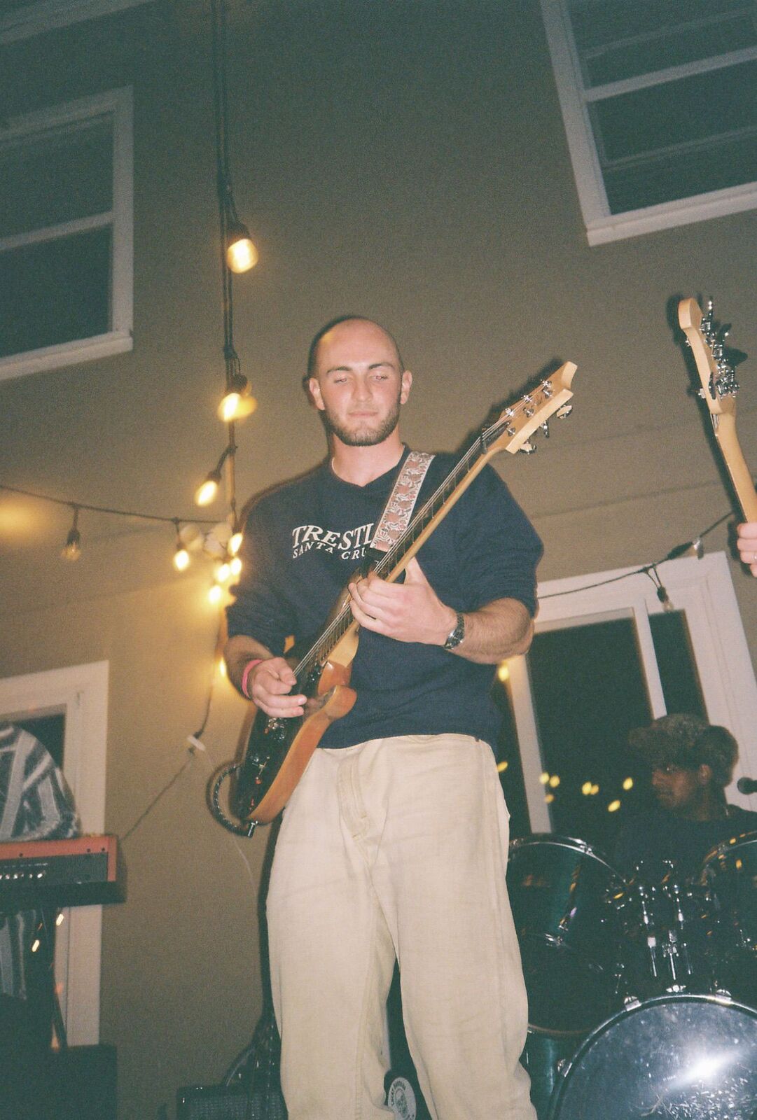 Playing electric guitar under string lights at a night show